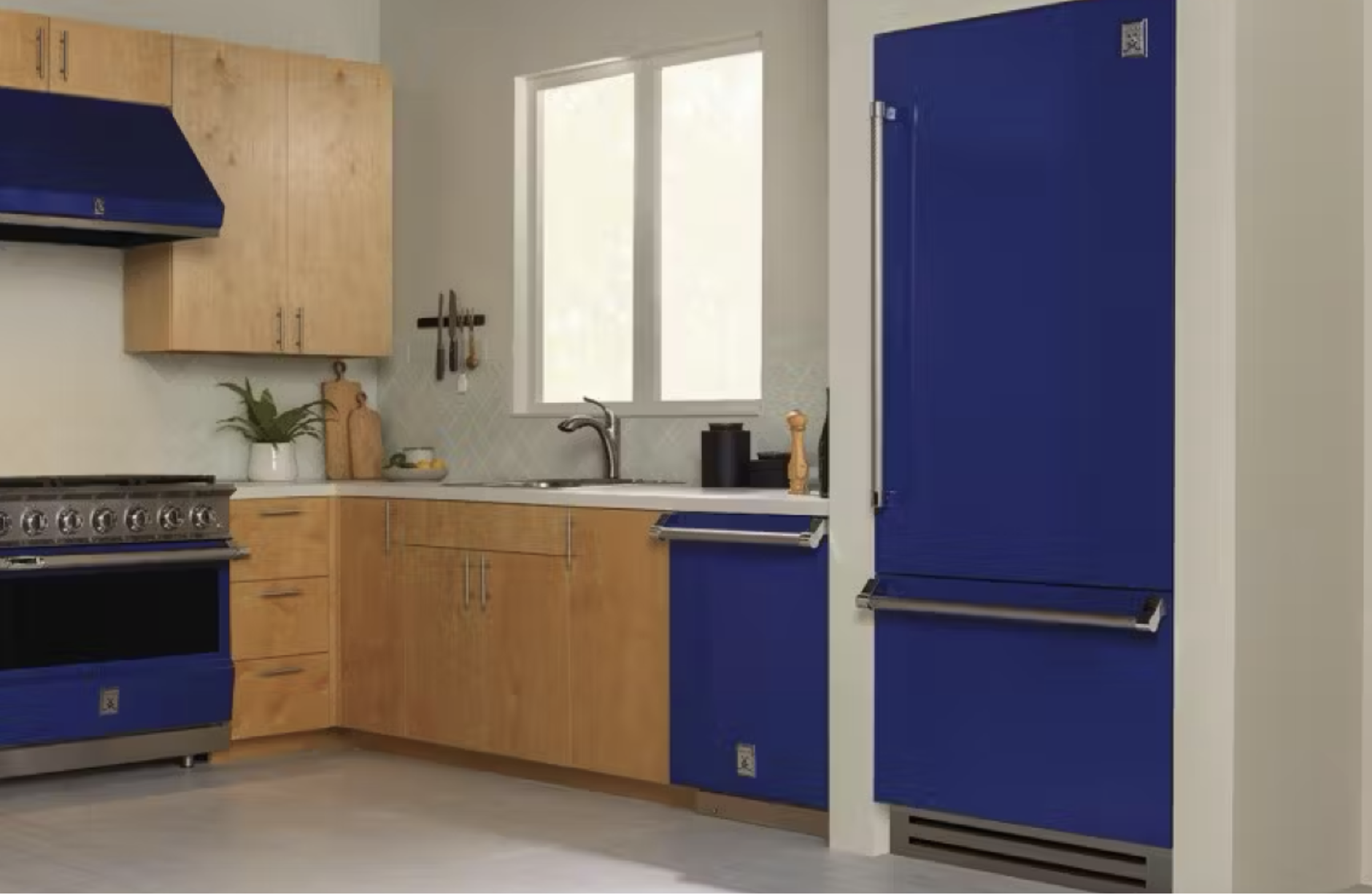 kitchen with honey colored wooden cabinets and royal blue kitchen appliances featuring a refrigerator with a bottom freezer